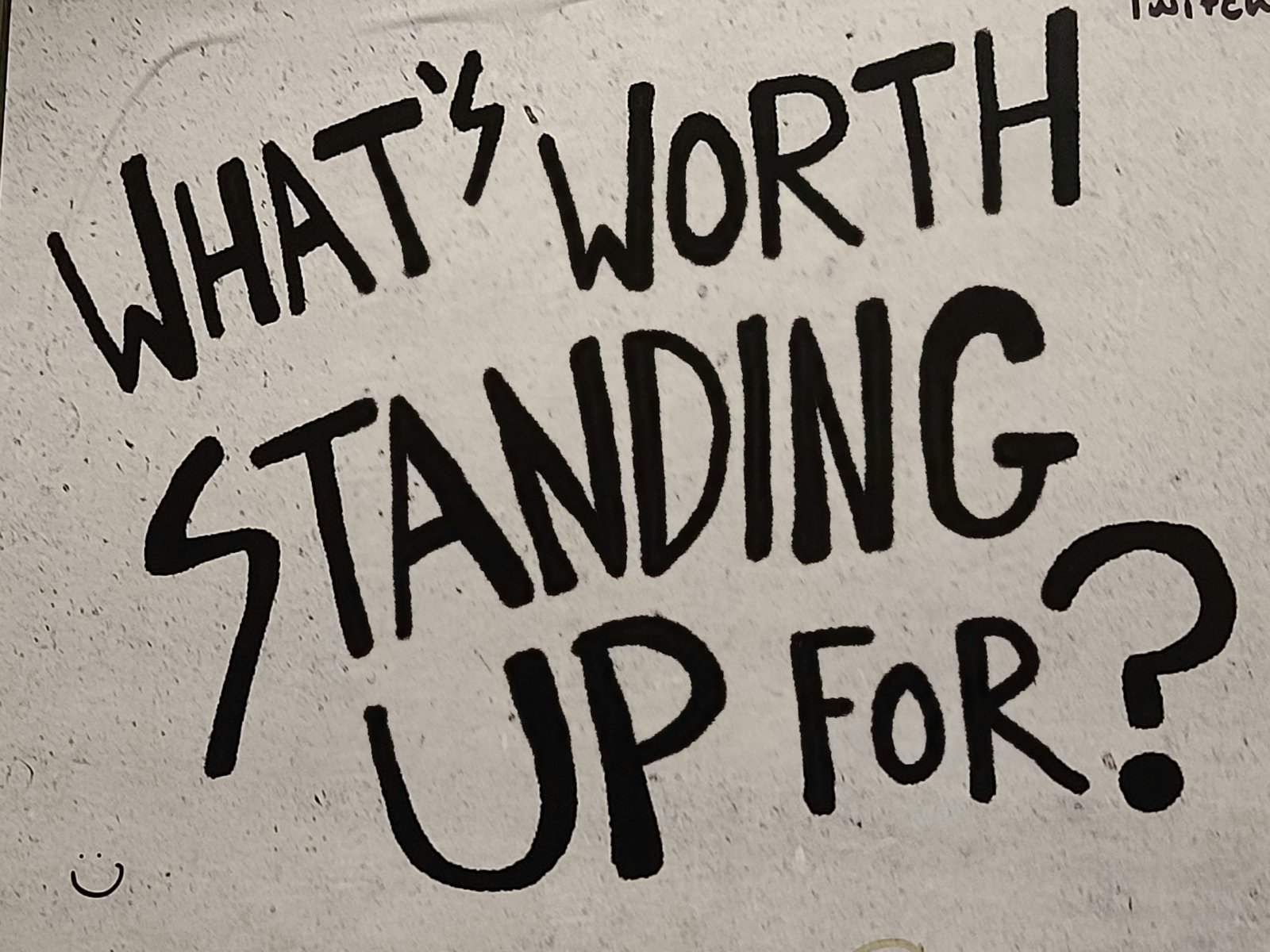 Cartaz escrito à mão: 'What's worth standing up for?'