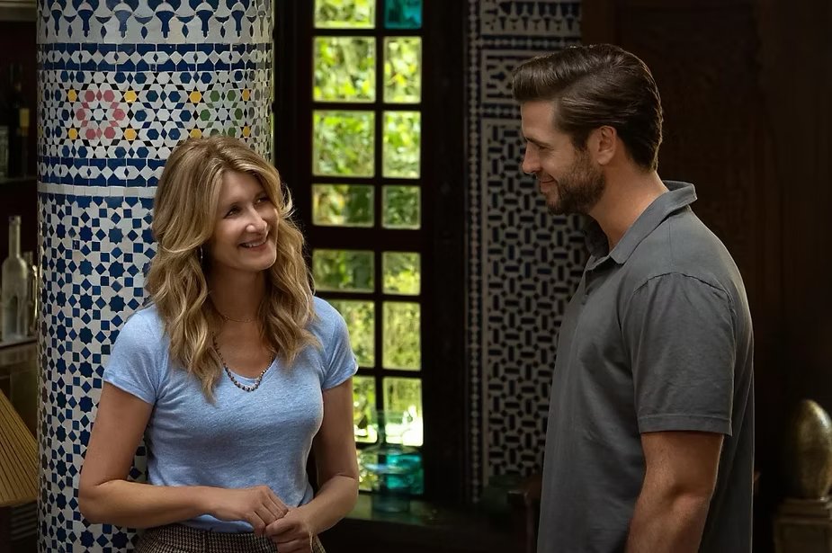 Cena de filme com um casal conversando e sorrindo em um ambiente decorado com azulejos